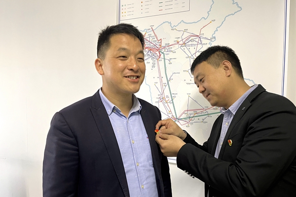 1648092486372444.jpg 支部书记为党员佩带党徽.JPG